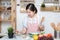 Asian young woman use finger slide on tablet screen prepare ingredients for cooking follow cooking online video clip on website in