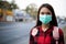 Asian Young woman walking in the city wearing face mask because of air pollution, particulates and for protection flu virus,