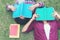 Asian young women and friends reading book on grass outdoor nature park for education