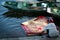 Asiatic Woman handwashes laundry in the amazing harbor with wooden boats moored. A unique scene of typical Vietnamese life