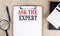 ASK THE EXPERT text on a clipboard on wooden background