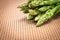 Asparagus bind with brown ribbon on brown wickerwork background