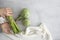 Asparagus bouquet in a hand, a couple of artichokes, a light colored napkin on a light wooden background