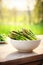 Asparagus in a bowl against the backdrop of the garden. Selective focus.