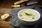 Asparagus cream soup with parsley garnish in a bowl, nutmeg grat