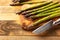 Asparagus on a cutting board with a knife, sliced. on wooden background. Culinary background. Diet. Delicious and healthy food