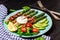 Asparagus and fried bacon and boiled eggs. Delicious breakfast or snack on a dark background, top view