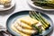 Asparagus with hollandaise sauce on a white plate, closeup. Healthy food concept. Generative AI