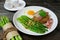 Asparagus in oyster sauce with fried rice,bacon and egg in white dish on wooden table background