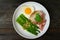 Asparagus in oyster sauce with fried rice,bacon and egg in white dish on wooden table background