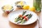 asparagus and red pepper wraps with lemon garnish on an earthenware plate