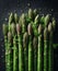 Asparagus stalks in a splash of water on the table.