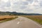 Asphalt country rural road in Germany through the green field an