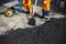 Asphalt laying. A worker repairs the road.