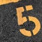 Asphalt parking lot with yellow lot line and yellow lot number 5, five, fifth