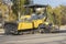 An asphalt paving machine works in the city center in the fall. Repair of road surfaces in a modern city using specialized