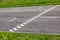 An asphalt racing track with a finish line among green grass and bushes. Horizontal orientation. High quality photo