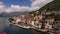 Asphalt road along the Perast embankment against the background of old houses