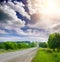 Asphalt road in countryside through green fields