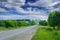 Asphalt road in the countryside through green summer fields