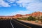 Asphalt road curving round corner with steep desert rock formations in Utah