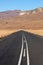 Asphalt Road Headed Towards Dry Wintery Mountains