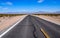 Asphalt road leading through steaming hot landscape of Death Valley National Park, California, USA. Super hot sunny day