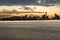 Asphalt road and modern city skyline at sunset