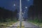 An asphalt road at night, lit by electric lanterns.