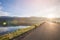 Asphalt road with reservoir on clearly blue sky and mountains.