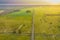 Asphalt road running through meadows and fields.