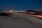 Asphalt road running through the sandy desert at night