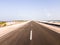 The asphalt road through sandy beaches