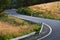 An asphalt road with sharp turns leads uphill