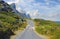 Asphalt road on Table Mountain with cloudy blue sky. Landscape of countryside roadway for traveling on mountain pass