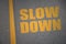 Asphalt road with text slow down near yellow line