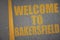 asphalt road with text welcome to Bakersfield near yellow line