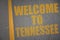 asphalt road with text welcome to tennessee near yellow line.