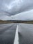 Asphalt road wet after rain goes into the distance, a part of the Chuisky tract, Altai, Russia