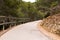 Asphalt road with wooden borders in a green nature park Sierra Gelada.