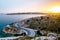 Asphalt serpentine road, park with mountains and rocks and sea with sunset on the background. Travel in Athens, Greece