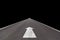 Asphalt straight street road way with white arrow traffic signs isolated on black background.