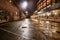 Asphalt street road in night city after the rain. Parking lot with graffiti on the brick walls