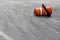 Asphalt street surface with orange traffic barrel on its side, safety and road hazard, copy space