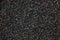 Asphalt texture pattern, large detailed dark textured tarmac closeup, horizontal copy space background, black grey colorful gravel