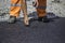 Asphalt worker patching by hands