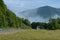 Asphalted mountain road, truck and motorcyclists in Carpathian mountains, in the Ukraine. Summer landscape, forest, sky