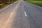 Asphalted road disappearing into the distance with the markings on cretinine on the road the glare of the sun the edges of the