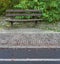 Asphhalt side road and cube stone old wooden park bench