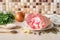 Aspic or jellied meat raw ingredients: pork leg shank on a plate, onion, garlic, salt, pepper, parsley and bay leaves on the